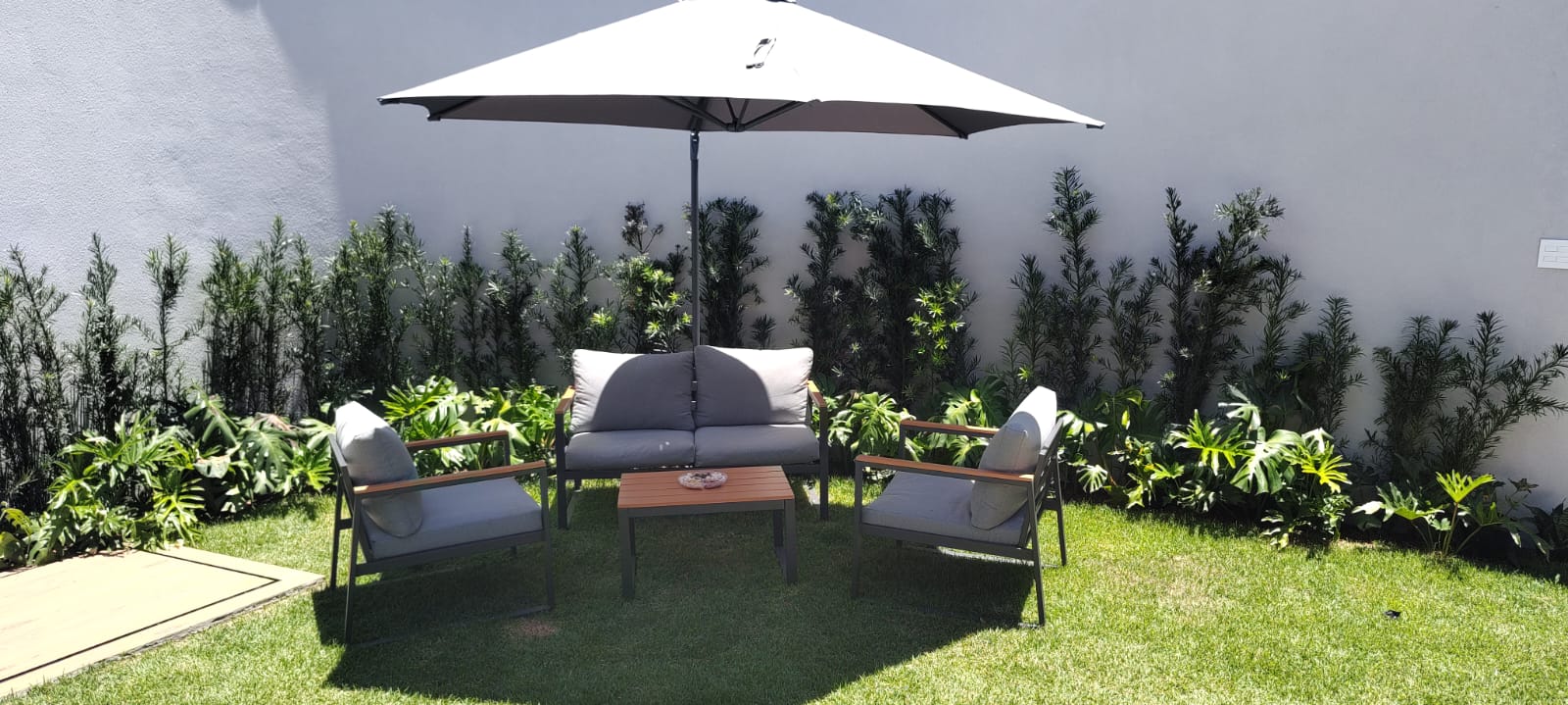 Lounge externo com sofás cinza sob luz natural