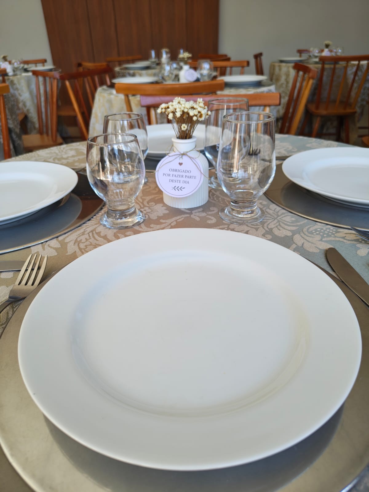 Mesa posta com louça branca e lembrança do chá revelação no salão