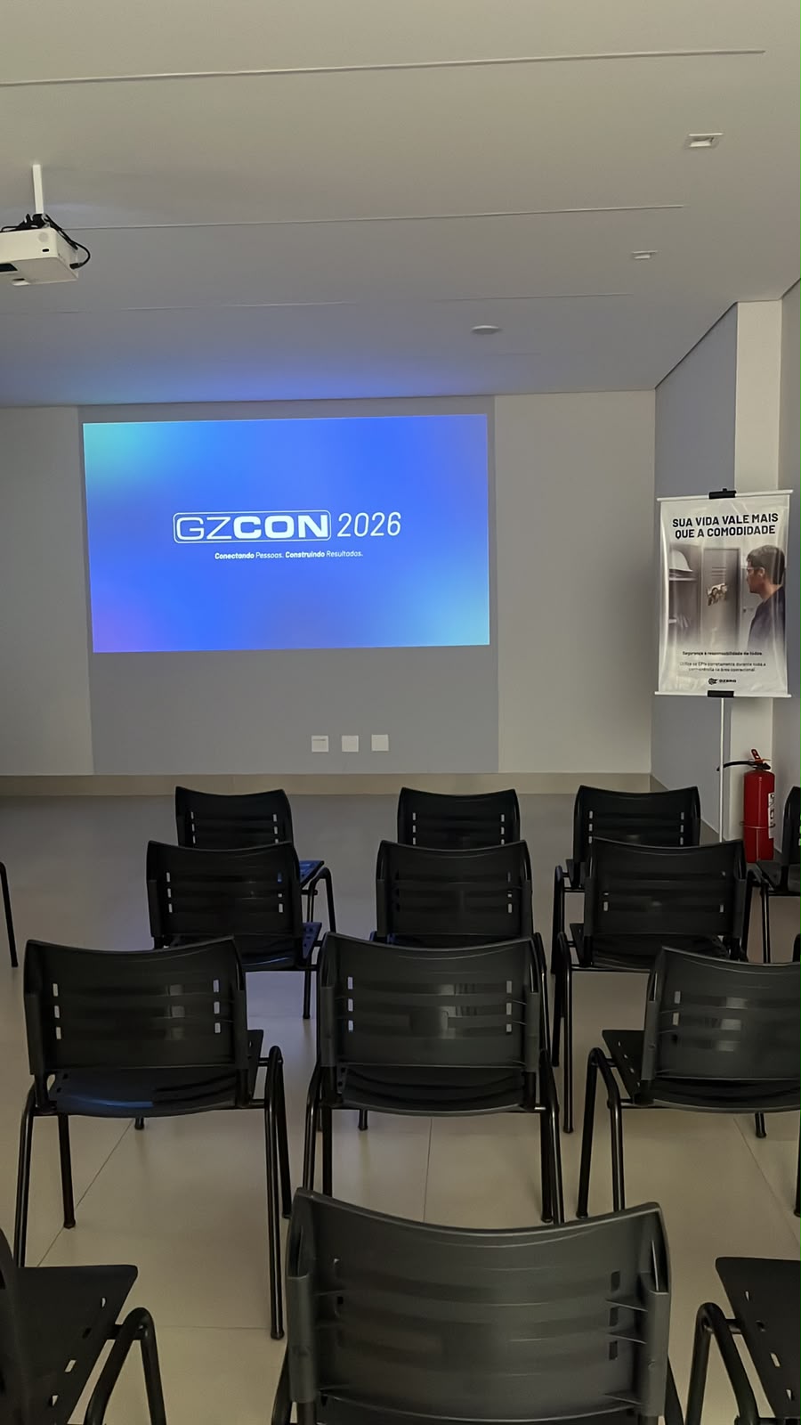 Auditório montado com cadeiras e projeção de evento corporativo